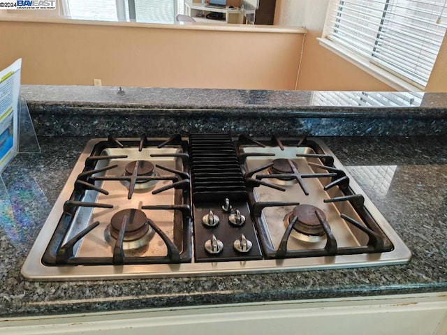 room details with dark stone countertops and stainless steel gas stovetop