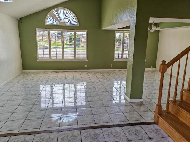 interior space featuring a chandelier, light tile patterned floors, a wealth of natural light, and lofted ceiling