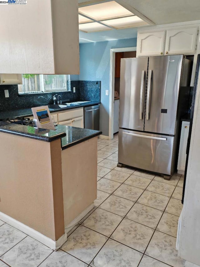 kitchen featuring backsplash, kitchen peninsula, white cabinetry, and appliances with stainless steel finishes