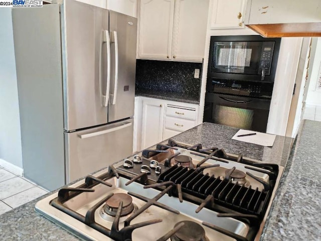 kitchen featuring decorative backsplash, white cabinetry, tile patterned flooring, and black appliances