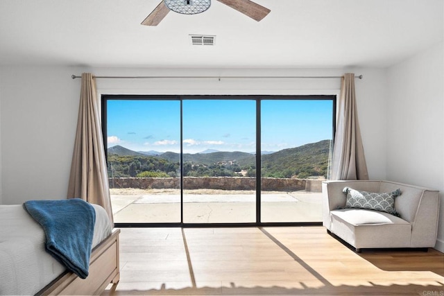 sitting room featuring a mountain view, hardwood / wood-style flooring, and plenty of natural light