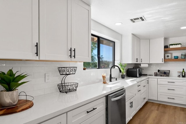 kitchen featuring white cabinets, dishwasher, and light wood-type flooring