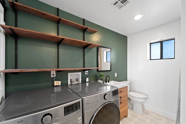 laundry area with separate washer and dryer, sink, and light tile patterned floors