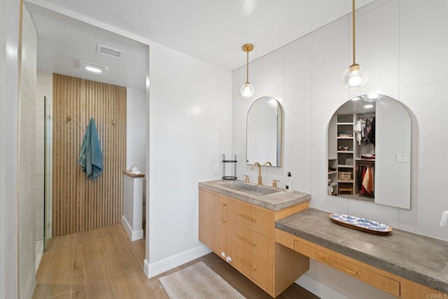 bathroom featuring vanity, wood-type flooring, and walk in shower