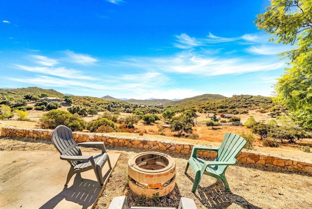 view of patio / terrace with a mountain view and a fire pit