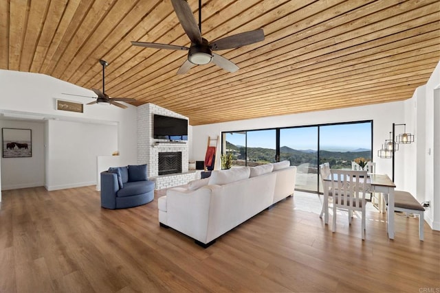 living room featuring wooden ceiling, vaulted ceiling, ceiling fan, a fireplace, and wood-type flooring