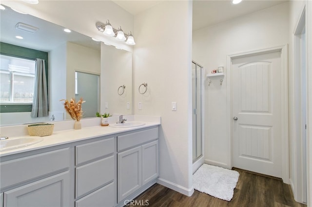 bathroom featuring hardwood / wood-style floors, vanity, and a shower with door