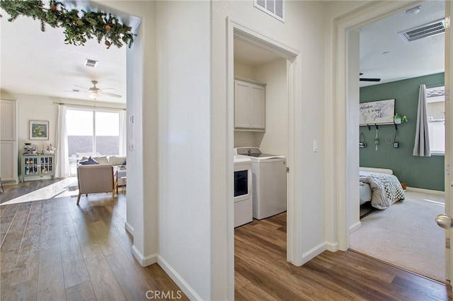 clothes washing area featuring washer and clothes dryer, ceiling fan, cabinets, and hardwood / wood-style floors