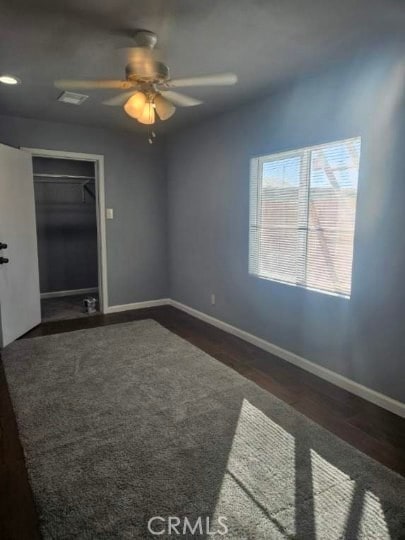 unfurnished room featuring ceiling fan and dark wood-type flooring