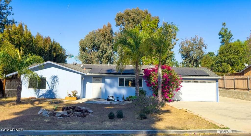 ranch-style house with solar panels and a garage