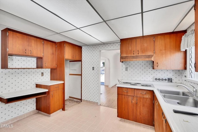 kitchen with a paneled ceiling, white electric stovetop, sink, and custom range hood