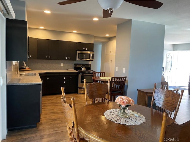 dining room featuring light hardwood / wood-style flooring, ceiling fan, and sink