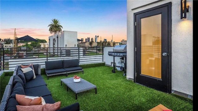 yard at dusk with an outdoor living space and a balcony