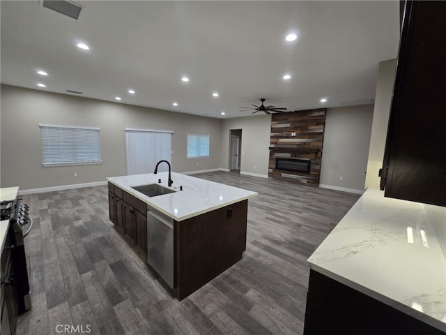 kitchen featuring dark hardwood / wood-style flooring, ceiling fan, sink, and an island with sink