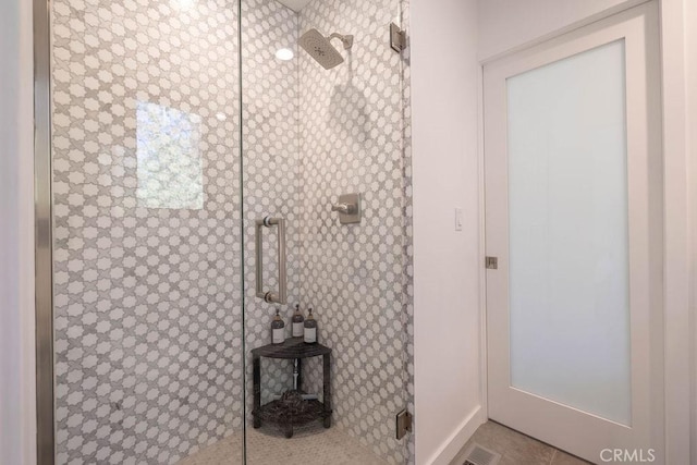 bathroom featuring tile patterned floors and a shower with shower door