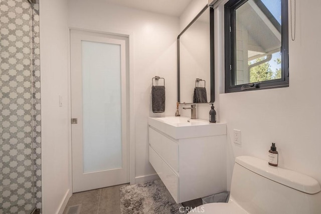 bathroom featuring vanity, toilet, and walk in shower