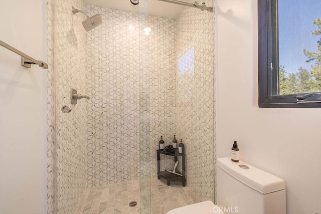 bathroom with toilet and tiled shower