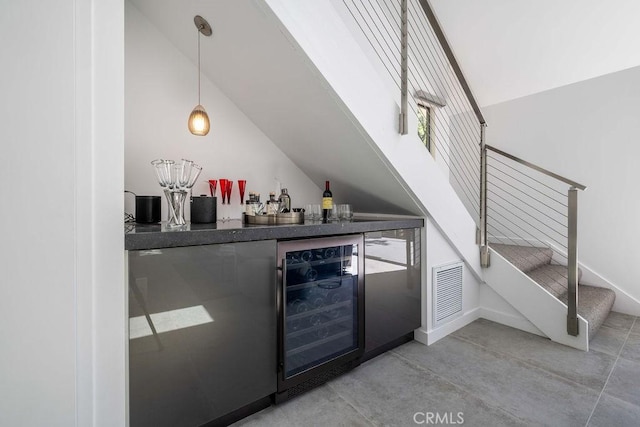 bar with wine cooler, pendant lighting, and lofted ceiling