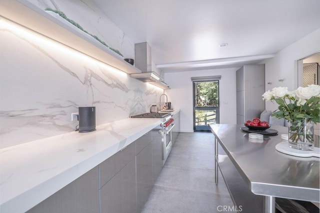 kitchen featuring sink, high end stainless steel range oven, gray cabinets, tasteful backsplash, and extractor fan