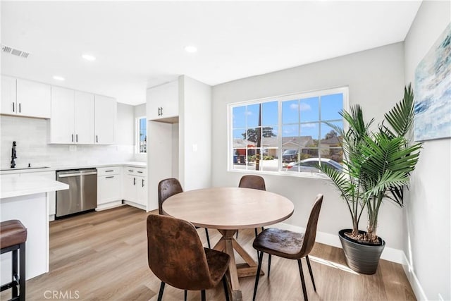 dining area with sink and light hardwood / wood-style floors