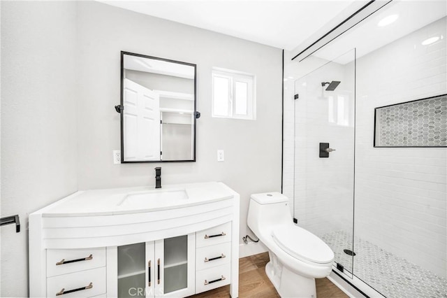 bathroom featuring a shower with shower door, wood-type flooring, sink, a baseboard heating unit, and toilet