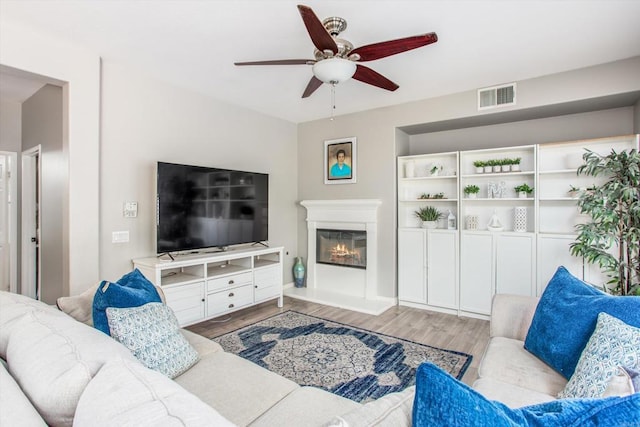 living room with ceiling fan and light wood-type flooring