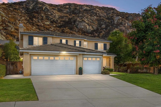 view of front of property featuring a garage and a lawn