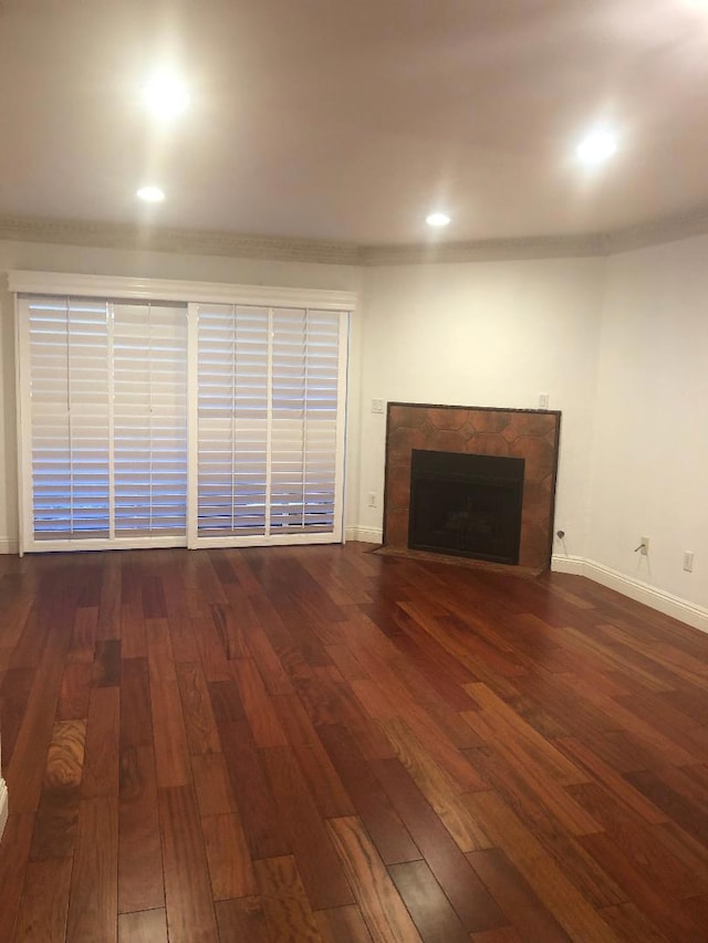 unfurnished living room featuring a high end fireplace and dark hardwood / wood-style floors