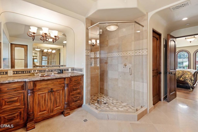 bathroom with tile patterned floors, vanity, a notable chandelier, and walk in shower