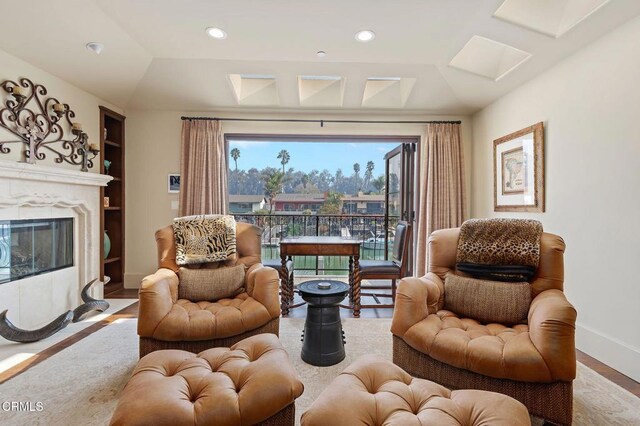 living area featuring a fireplace, hardwood / wood-style floors, and vaulted ceiling