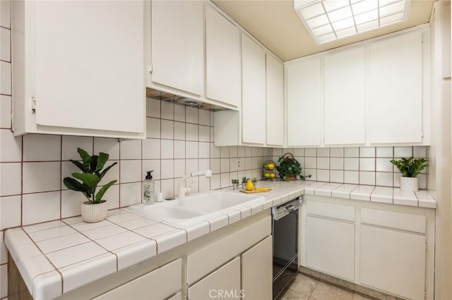 6542 Ocean Crest Dr Unit C-309, Rancho Palos Verdes, CA 90275 - kitchen featuring black dishwasher, decorative backsplash, white cabinetry, and light tile patterned flooring