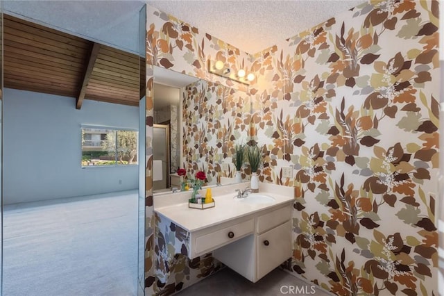 6542 Ocean Crest Dr Unit C-309, Rancho Palos Verdes, CA 90275 - bathroom featuring wallpapered walls, vanity, a textured ceiling, and beam ceiling