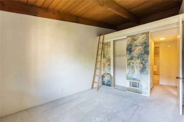 unfurnished living room with carpet flooring, beam ceiling, and wooden ceiling