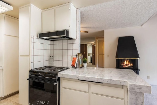 6542 Ocean Crest Dr Unit C-309, Rancho Palos Verdes, CA 90275 - kitchen featuring black / electric stove, under cabinet range hood, decorative backsplash, light countertops, and a peninsula