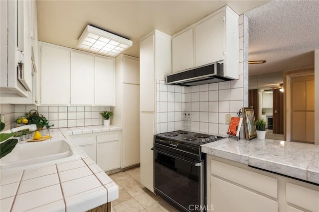 6542 Ocean Crest Dr Unit C-309, Rancho Palos Verdes, CA 90275 - kitchen featuring black electric range oven, under cabinet range hood, tasteful backsplash, a ceiling fan, and white cabinets