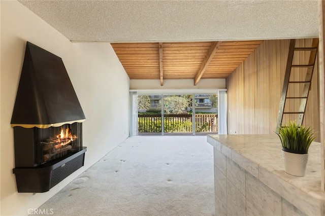 6542 Ocean Crest Dr Unit C-309, Rancho Palos Verdes, CA 90275 - unfurnished living room featuring carpet flooring, a wood ceiling with exposed beams, and a multi sided fireplace