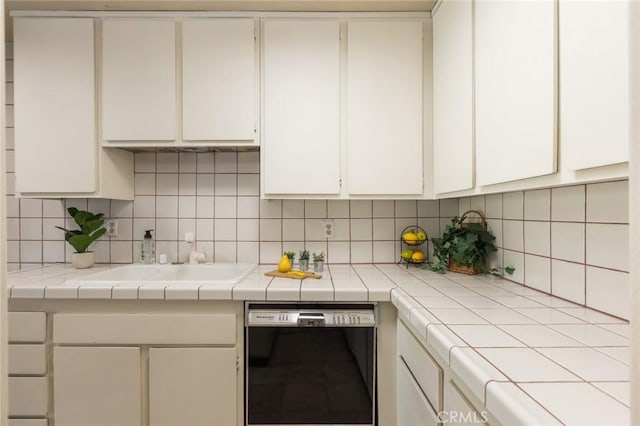 6542 Ocean Crest Dr Unit C-309, Rancho Palos Verdes, CA 90275 - kitchen with black dishwasher, white cabinetry, and backsplash