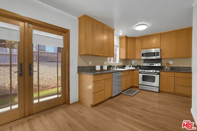 kitchen featuring appliances with stainless steel finishes, light hardwood / wood-style floors, and a healthy amount of sunlight