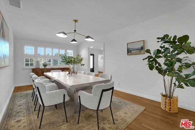 dining space featuring hardwood / wood-style flooring and a notable chandelier