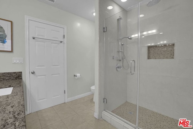 bathroom featuring tile patterned flooring, vanity, toilet, and an enclosed shower