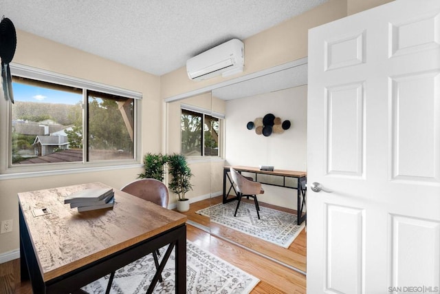 office with a wall mounted air conditioner, a textured ceiling, and a wealth of natural light