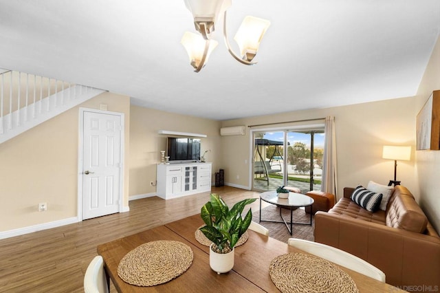 living room with a wall mounted AC, hardwood / wood-style floors, and a chandelier