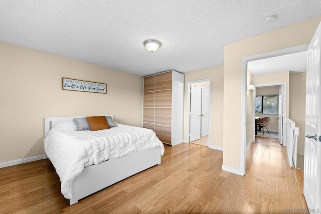 bedroom with hardwood / wood-style floors and a textured ceiling