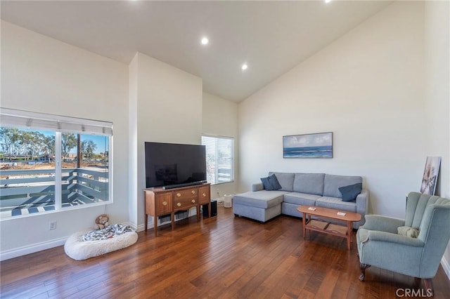 living room featuring dark hardwood / wood-style flooring, plenty of natural light, and high vaulted ceiling