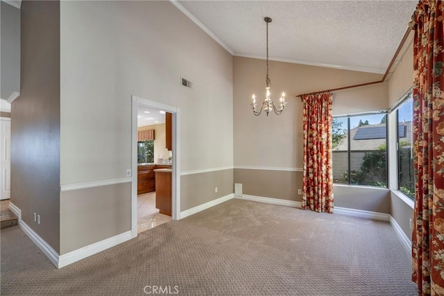 spare room featuring light colored carpet, crown molding, and a chandelier