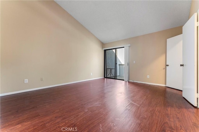 spare room with dark hardwood / wood-style flooring, lofted ceiling, and a textured ceiling