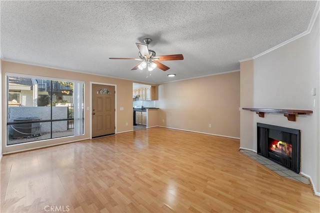 unfurnished living room featuring ceiling fan, ornamental molding, a textured ceiling, and light hardwood / wood-style flooring