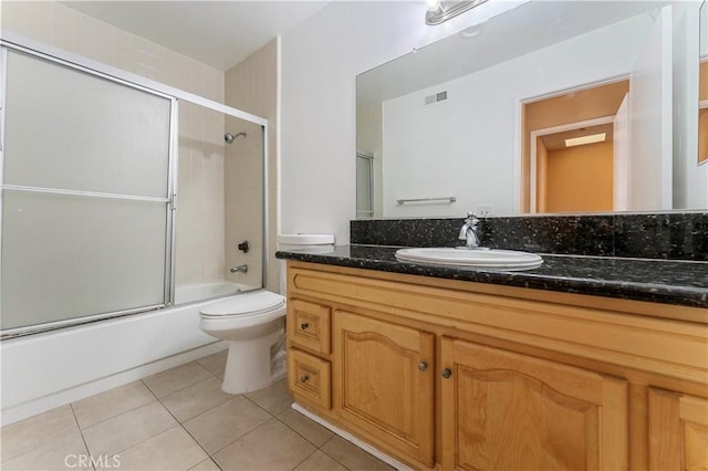 full bathroom featuring tile patterned floors, vanity, toilet, and combined bath / shower with glass door