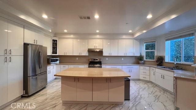 kitchen featuring white cabinetry, a kitchen island, and stainless steel appliances