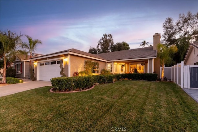 single story home featuring a lawn and a garage